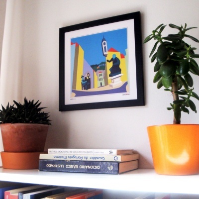 Prateleira com livros, plantas em vasos e quadro colorido na parede