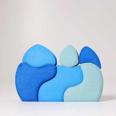 Peças de madeira azul empilhadas decorativamente sobre superfície branca