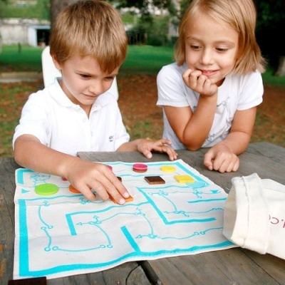 Crianças jogando jogo de tabuleiro em tecido ao ar livre