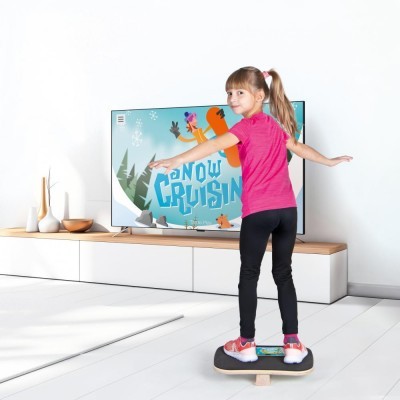 Menina usando prancha de equilíbrio a jogar videojogo de neve numa sala moderna.
