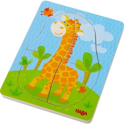 Puzzle de madeira com girafa e pássaro sobre fundo azul com árvores verdes.