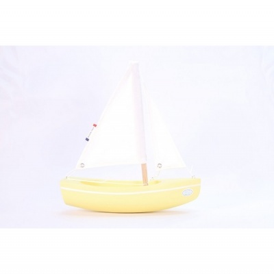 Barco de brinquedo amarelo com vela branca e detalhes coloridos