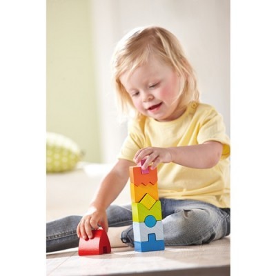 Criança a brincar com blocos de empilhar coloridos no chão