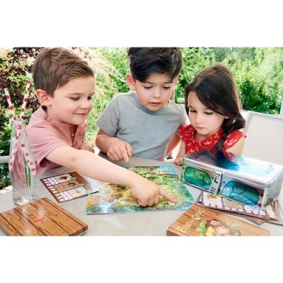 Crianças a jogar com tabuleiro de jogo infantil colorido e acessórios numa mesa ao ar livre