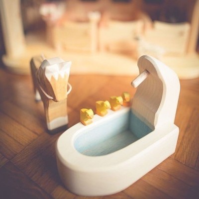 Banheira de madeira com patos amarelos e cavalo de madeira