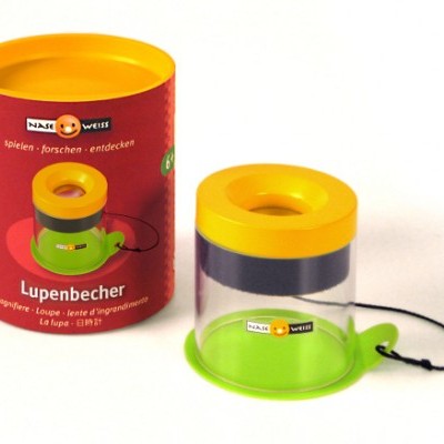 Recipiente de lupa infantil com base verde, tampa amarela e embalagem vermelha com texto.