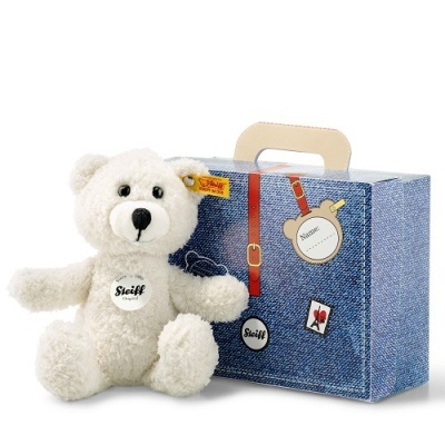 urso de peluche branco e mala azul com textura de ganga
