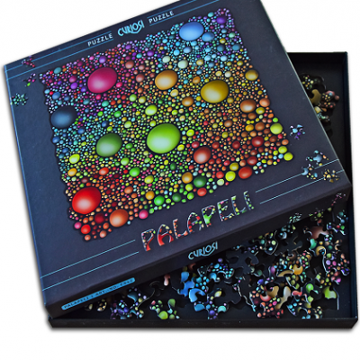 Caixa e peças de puzzle colorido da marca Curiosi com padrão de bolhas