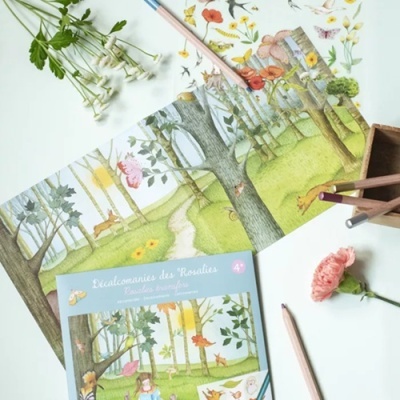 Livro para colorir sobre mesa branca com lápis de cor e flores