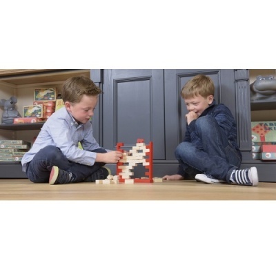 Crianças a jogar com um jogo de equilíbrio em madeira num ambiente interior