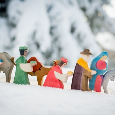 Figuras de madeira coloridas do presépio na neve