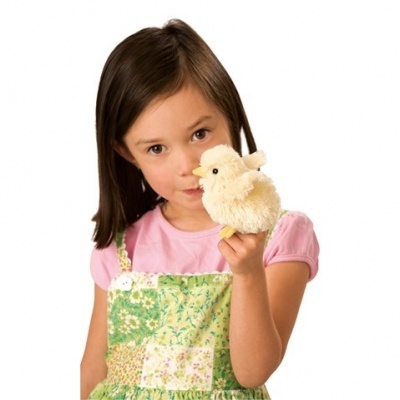 Menina com vestido verde e camisola rosa segurando brinquedo de pelúcia amarelo