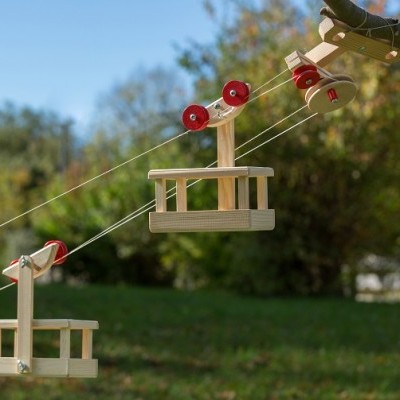 Teleférico de madeira com rodas vermelhas ao ar livre