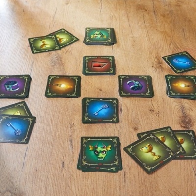 Cartas de jogo coloridas com imagens diversas em mesa de madeira clara.