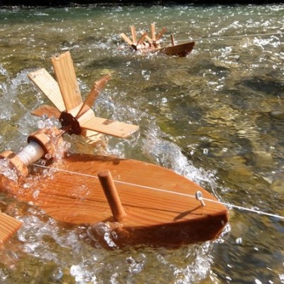 Barcos de madeira com rodas de pás em água clara e pedra