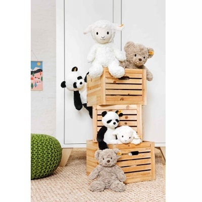 Peluches de carneiro, urso e panda organizados em caixas de madeira num ambiente interior