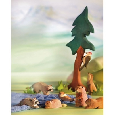 Figuras de madeira de animais e árvore em cenário natural colorido