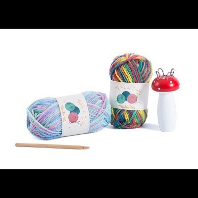 Novelos de lã colorida e descosedor com agulha em fundo branco.