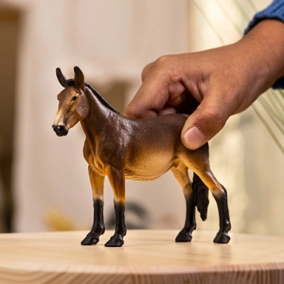 Figura de cavalo castanho e preto numa mesa de madeira