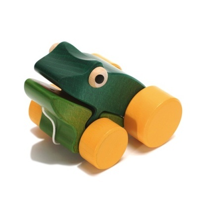 Brinquedo de madeira verde em forma de crocodilo com quatro rodas amarelas