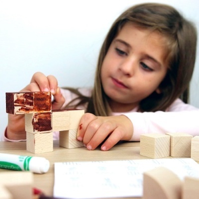 Menina a brincar com blocos de madeira