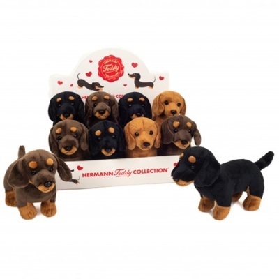 Peluches de cães da coleção HERMANN Teddy em cores castanho e preto num display branco.