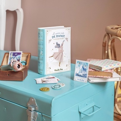 Livro infantil e objetos de jogo sobre mala azul claro