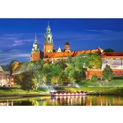 Castelo à beira do rio com torres iluminadas e árvores verdes