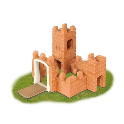 Castelo de brinquedo castanho com porta branca sobre base verde