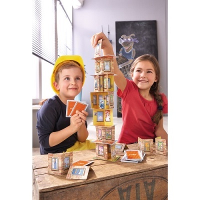 Crianças a construir uma torre com blocos de madeira coloridos numa mesa de madeira