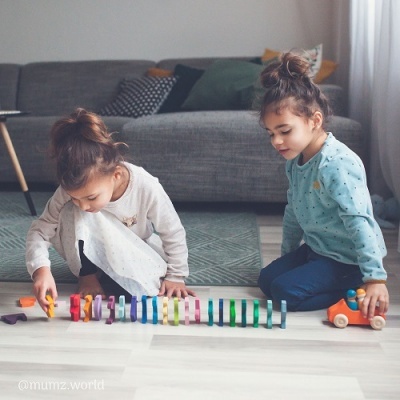 Crianças a jogar com brinquedos coloridos no chão da sala