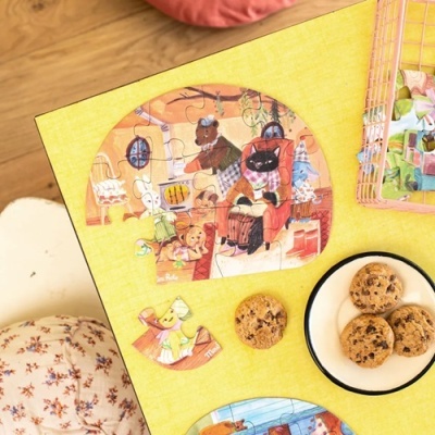 Puzzle de madeira infantil com animais ilustrados sobre mesa amarela com bolachas ao lado