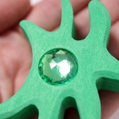 Forma de madeira verde com pedra facetada verde embutida