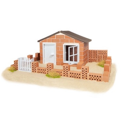 Modelo de casinha de tijolos com porta e janela brancas e vedação de tijolos