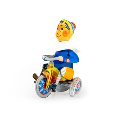 Brinquedo retro em metal com figura colorida numa bicicleta sobre fundo branco.