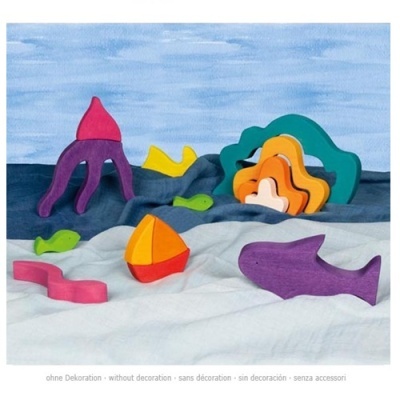 Brinquedos de madeira coloridos em formas marinhas sobre tecido azul e branco