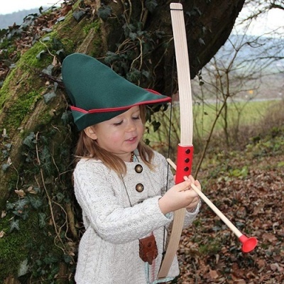 Menina com arco e flecha de brinquedo ao ar livre