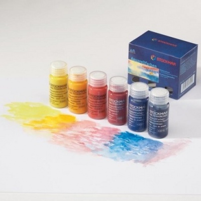 Set de tintas coloridas Stockmar com caixa azul, seis frascos e tinta aplicada no papel