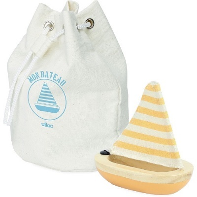 Saco branco de tecido com barco azul impresso e pequeno barco de madeira com vela às riscas amarelas e brancas