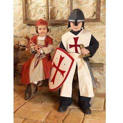 Crianças com fantasias medievais, cavaleiro e princesa, em ambiente rústico de pedra.