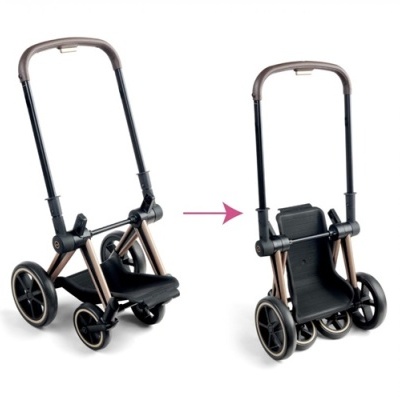 Carrinho de bebé preto e dourado com assento preto e rodas, dobrável para facilitar armazenamento