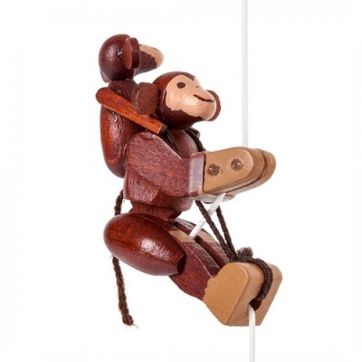 Boneco macaco em madeira castanha pendurado numa corda branca
