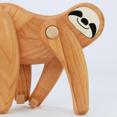 Peça decorativa de madeira em forma de preguiça com articulações móveis