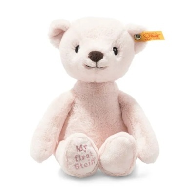 Urso de peluche cor rosa claro com etiqueta amarela na orelha