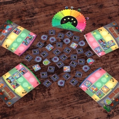 Jogo de tabuleiro com tabuleiros coloridos, peças de personagens e leque de pontuação