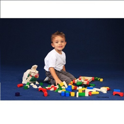 Criança com blocos de construção coloridos no chão azul