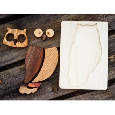 Quebra-cabeças de madeira em forma de coruja com peças coloridas e base clara