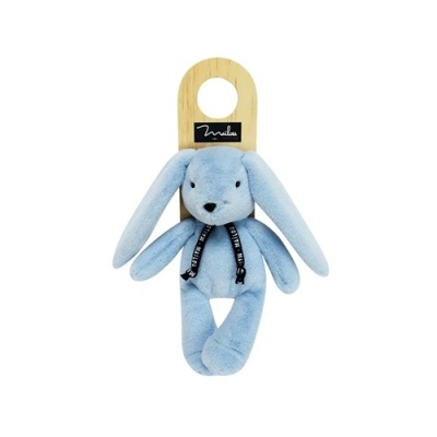 Ursinho de peluche azul claro com fita preta pendurado numa placa de madeira com marca