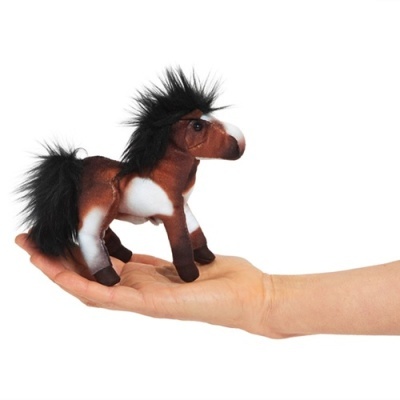 Boneco de pelúcia de cavalo castanho e branco com crina e rabo pretos na mão
