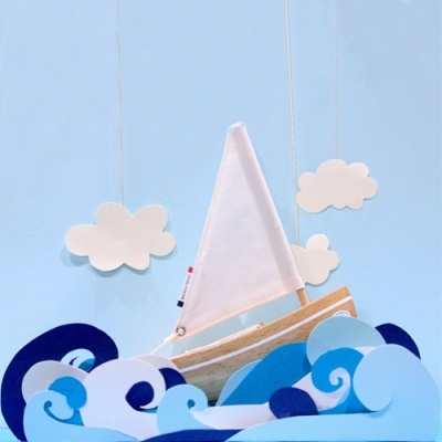 Barco de vela decorativo com ondas e nuvens de papel
